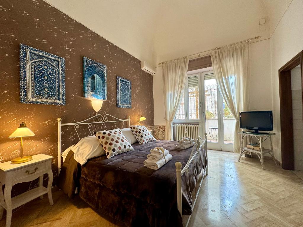 sypialnia z łóżkiem i telewizorem w obiekcie Aedes B&B Il Giardino dei Sogni w mieście Lecce