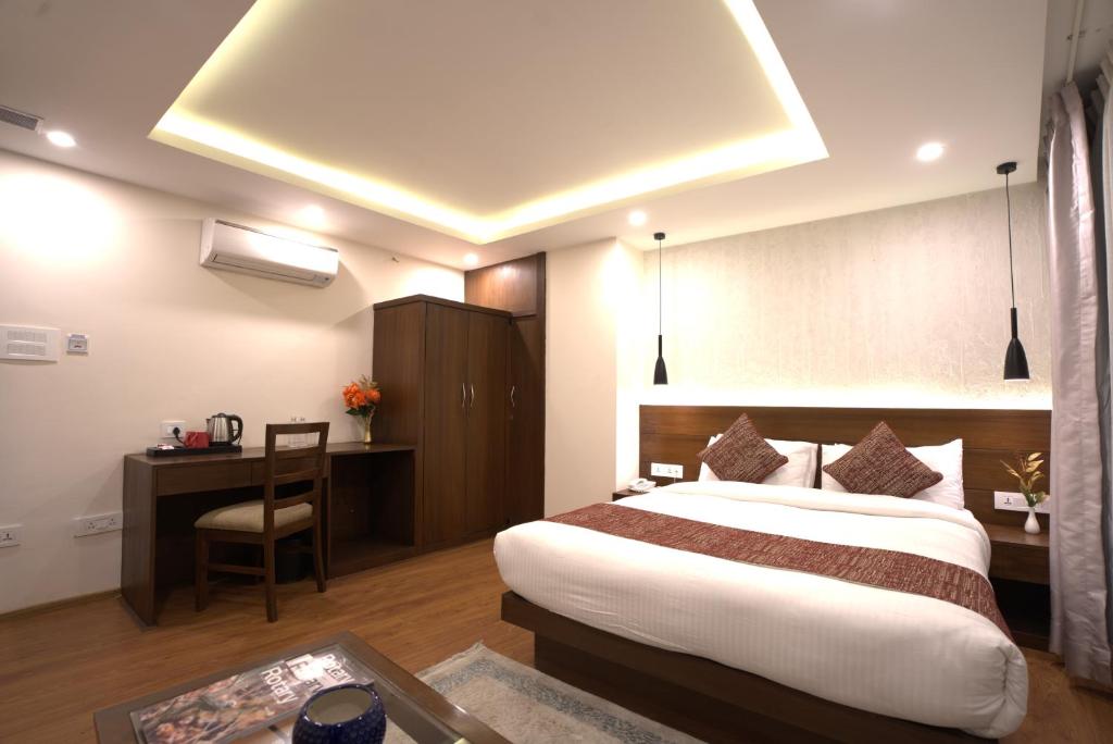 Habitación de hotel con cama grande y escritorio. en Apex Business Hotel, en Katmandú