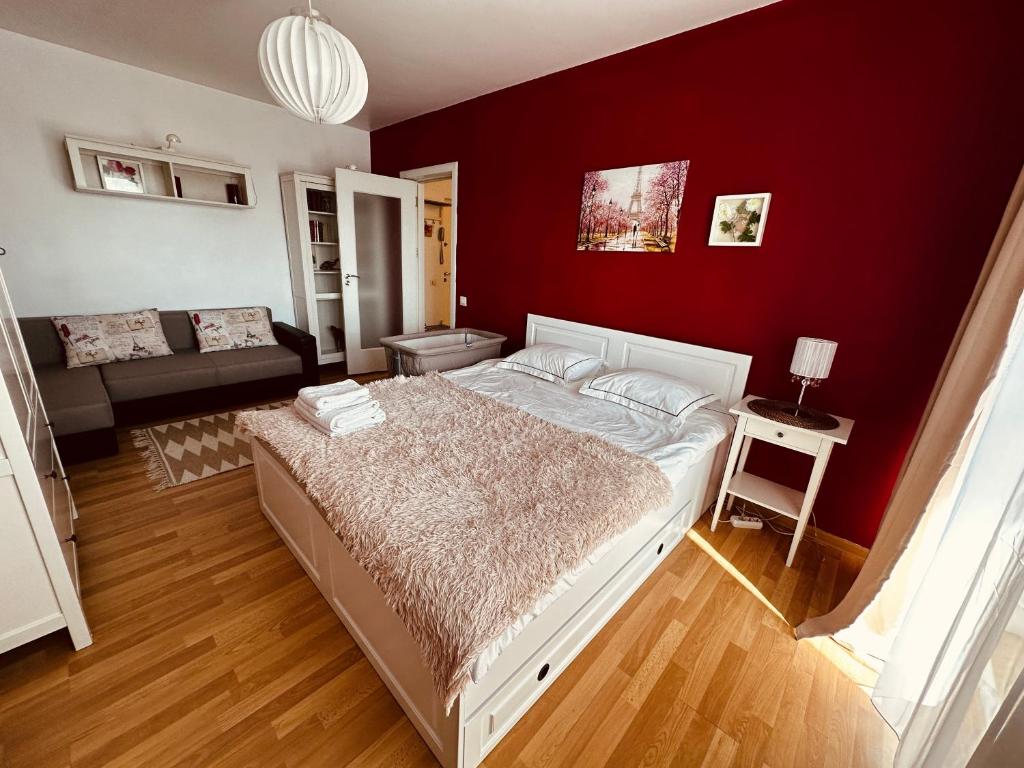 a bedroom with a bed and a red wall at Le Petit Paris- Central , Dorobanți with a view in Bucharest