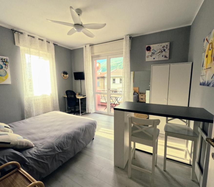 1 dormitorio con cama, escritorio y mesa en Casa vacanze "La Begonia", en Morbegno