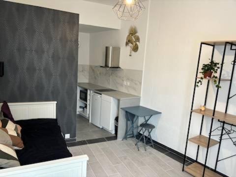 un salon avec un canapé et une table dans l'établissement Studio calme avec un lit, à Bordeaux