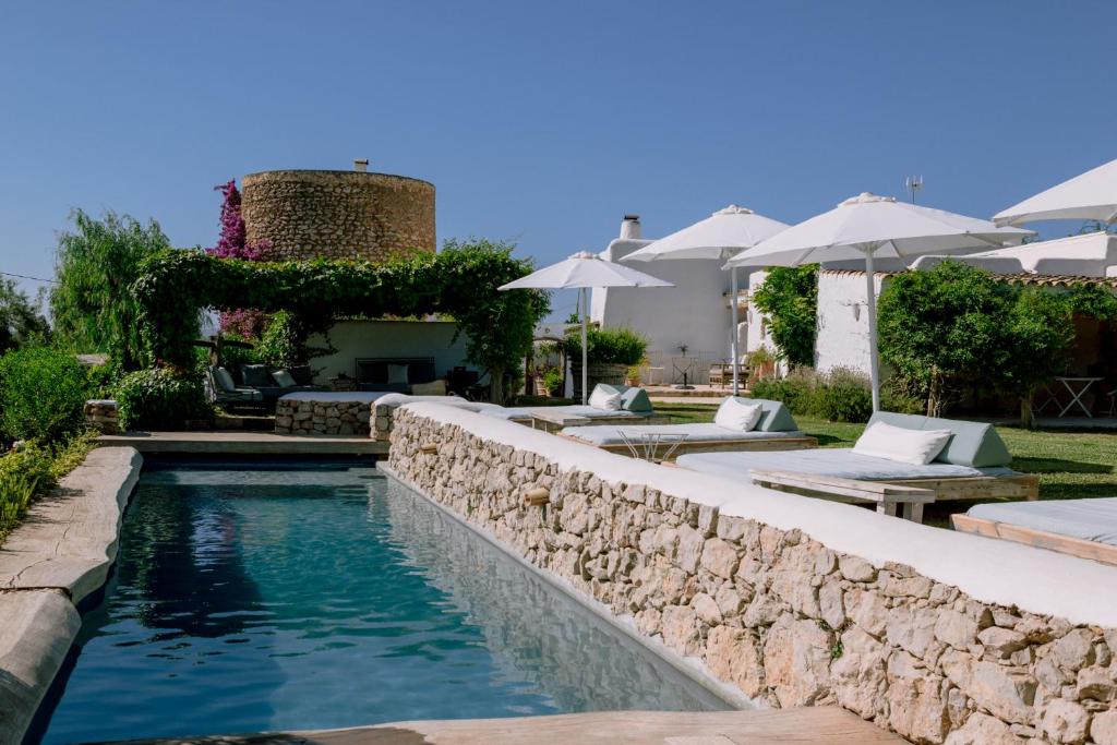 uma piscina com uma parede de pedra ao lado de uma casa em Can Quince de Balafia - Turismo de Interior em Sant Llorenç de Balafia