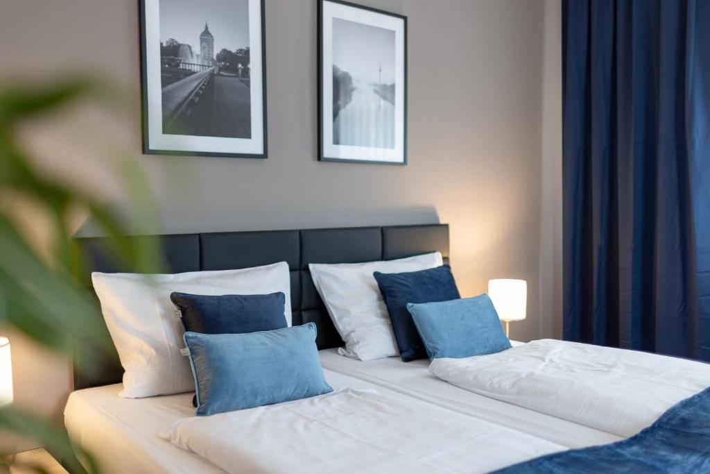 a bedroom with two beds with blue and white pillows at Hotel Wegener in Mannheim