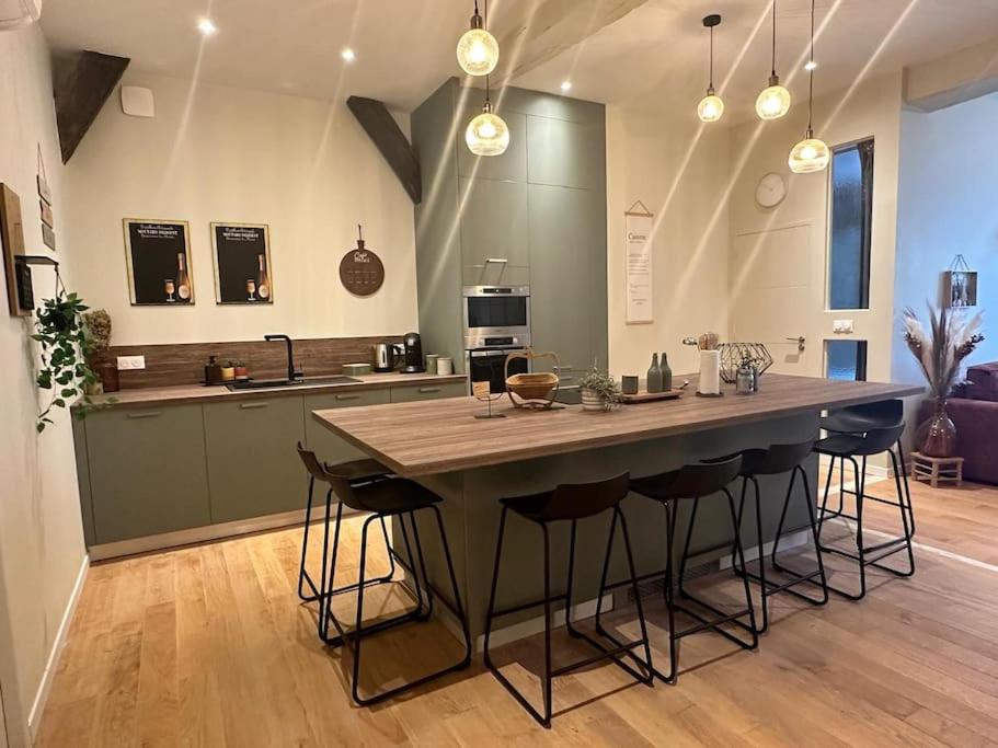 une grande cuisine avec une grande table et des tabourets de bar dans l'établissement Appart familial hyper centre Troyes, à Troyes