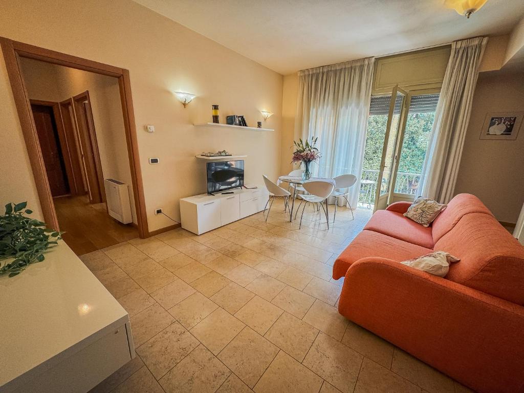 ein Wohnzimmer mit einem orangenen Sofa und einem Tisch in der Unterkunft Casa Paolina in Lucca