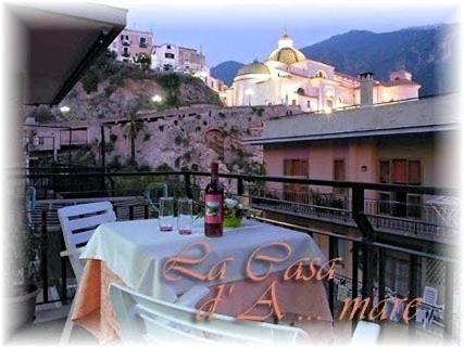 een tafel met een fles wijn op een balkon bij La casa D'a...mare in Maiori