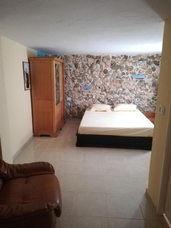 a bedroom with a bed and a wooden cabinet at Belle maison bord de mer rdc in El Haouaria