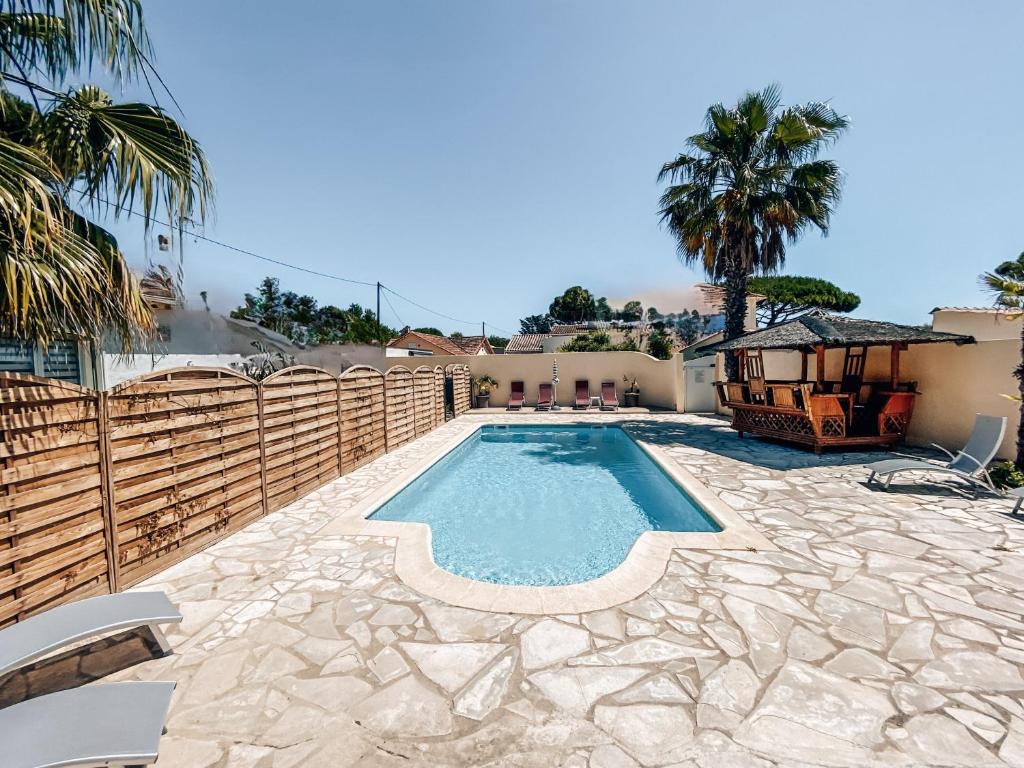 una piscina en el patio trasero de una casa en Rêve D'azur, en Bord de Mer à La Nartelle, Piscine, Parking & Terrasse BBQ, Wifi et Draps Inclus plage à pied en Sainte-Maxime