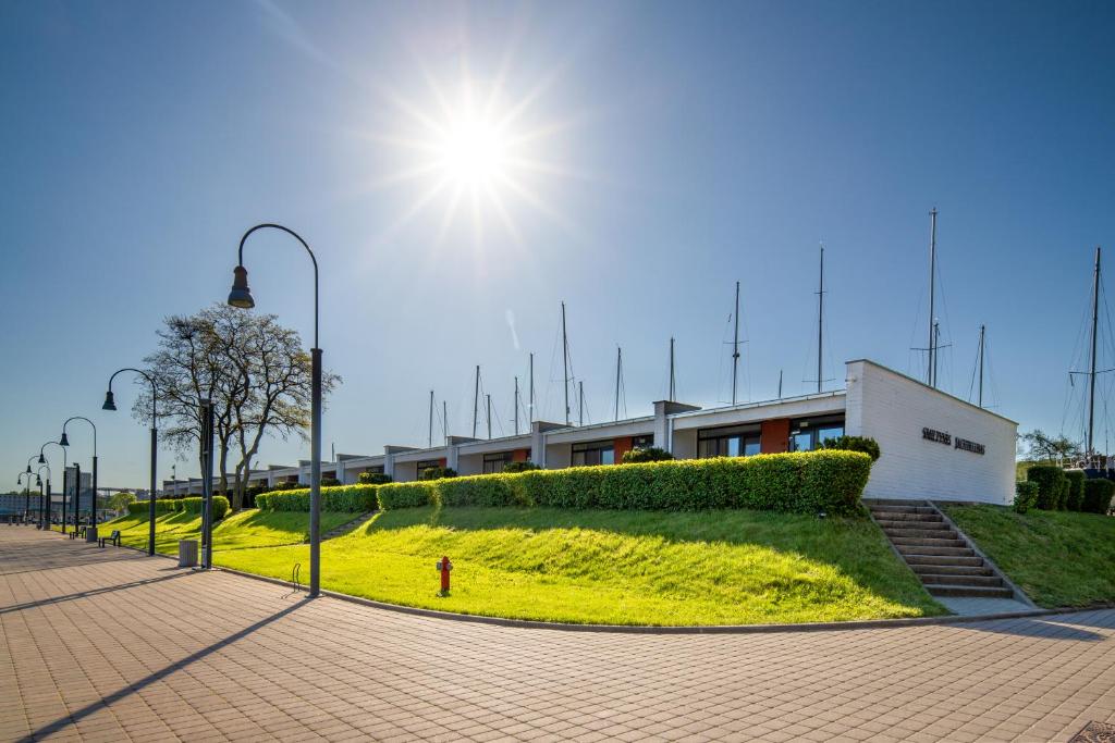 クライペダにあるSmiltynės Jachtklubasの空に太陽が輝く建物