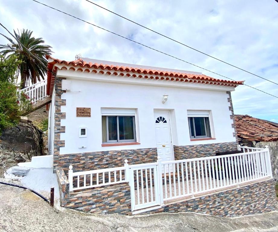una casa blanca con una valla delante en Casa Los Palmeros Perdomo en Alojera
