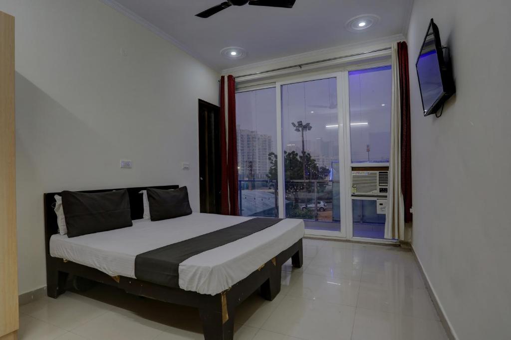 een slaapkamer met een bed en een groot raam bij Omi Inn Manesar in Manesar