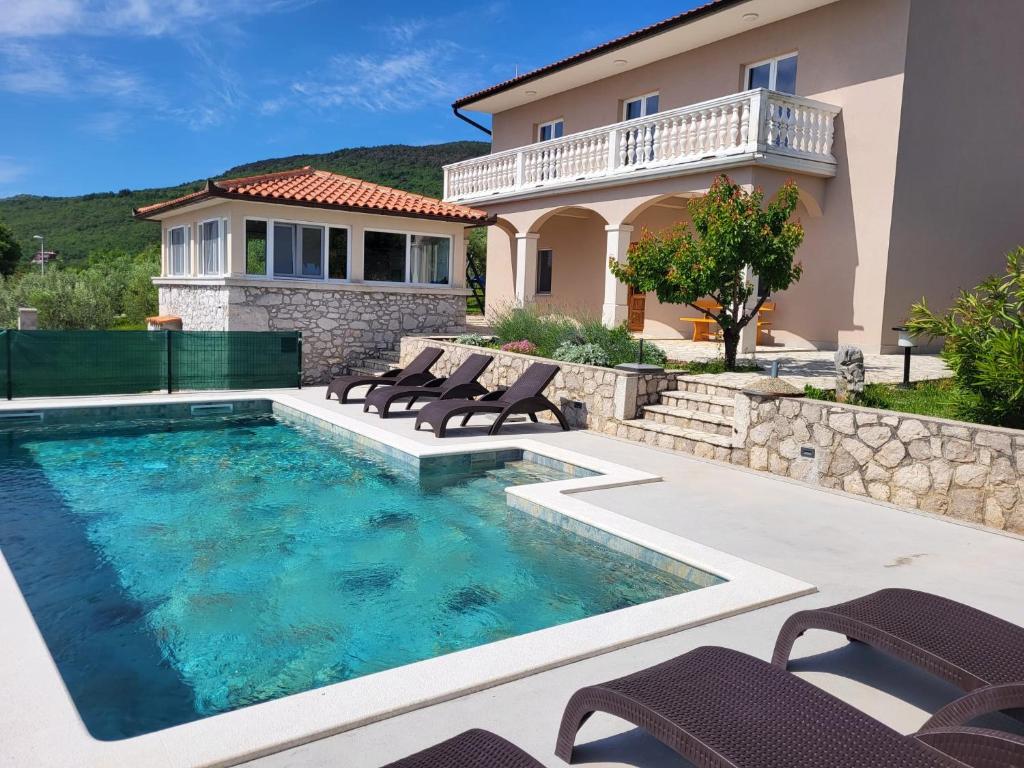 una piscina con sillas y una casa en House Olive Bay View, en Drenje