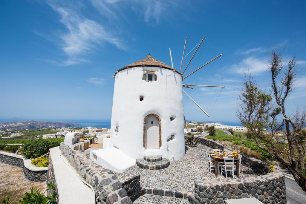 a windmill on top of a hill with a table at Anemoscope Windmill Villa in Pirgos
