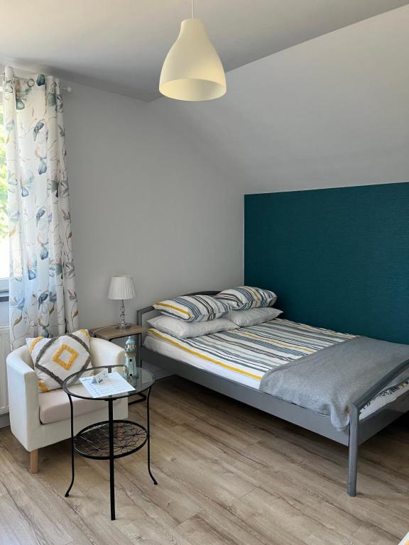 een slaapkamer met een bed, een bank en een tafel bij Bukszpan in Sasino