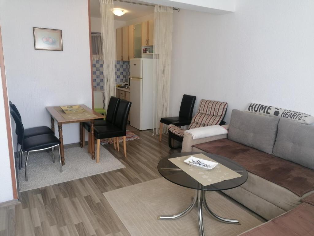 sala de estar con sofá, mesa y sillas en Stari Grad Apartment-free parking, en Sarajevo