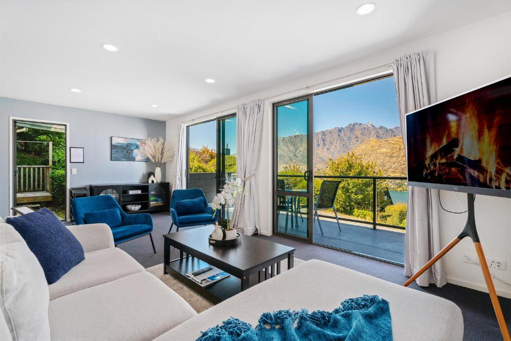 a living room with a white couch and a tv at Goldfield Holiday Home in Queenstown