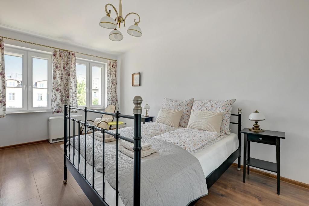 a bedroom with a bed and a chandelier at Apartament Gdańsk in Gdańsk