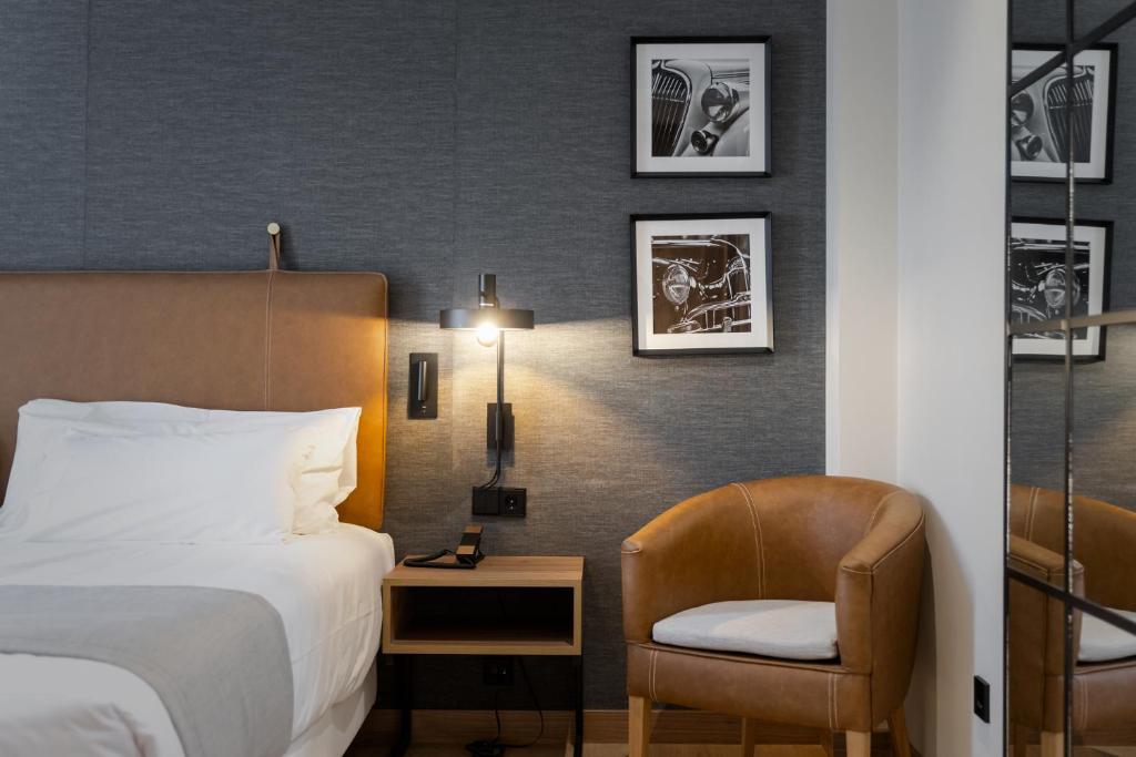 um quarto de hotel com uma cama e uma cadeira em Hotel & Spa Convento San Francisco em Soria