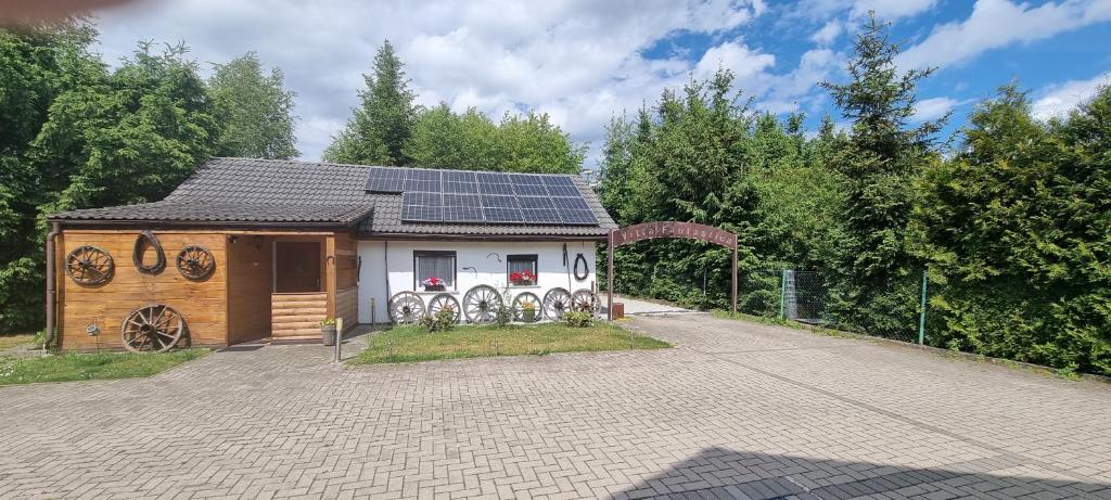 une petite maison avec des panneaux solaires en haut dans l'établissement Villa Fantastica Apartments, à Mysłakowice
