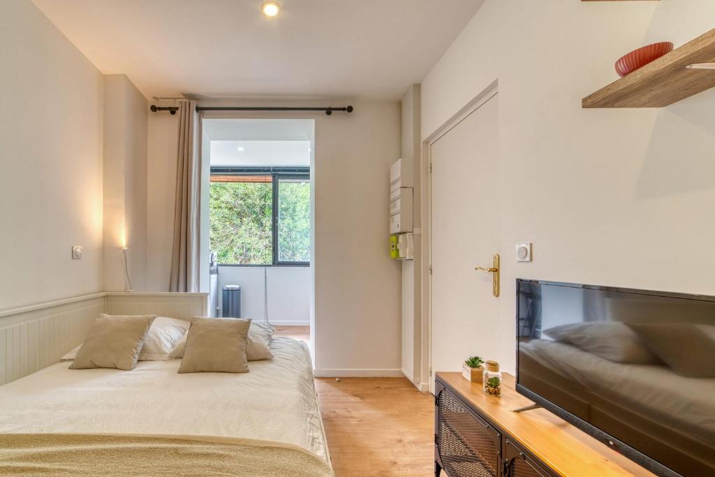 une chambre avec un lit et une télévision à écran plat dans l'établissement Le Petit Gerland - Agréable à 1 minute du métro B, à Lyon