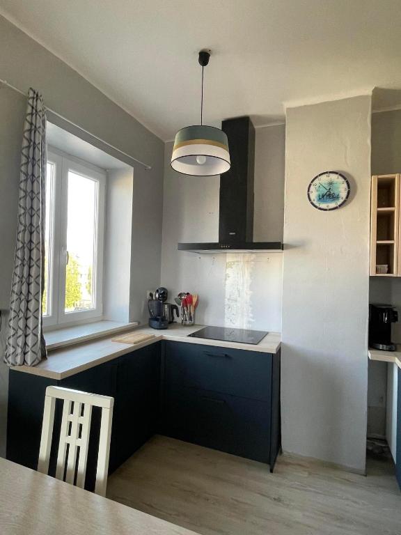 a kitchen with a sink and a table and a window at Soucis au vent 2 in De Panne
