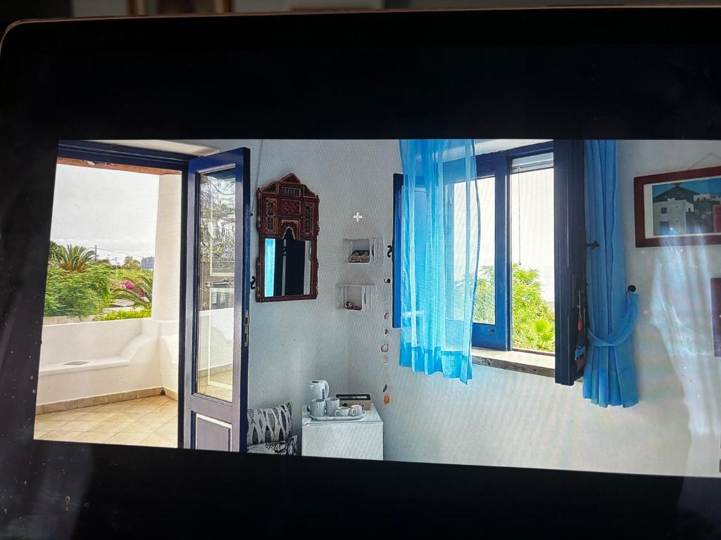 ストロンボリにあるThe lighthouse roomの青いカーテンと窓が備わる客室です。