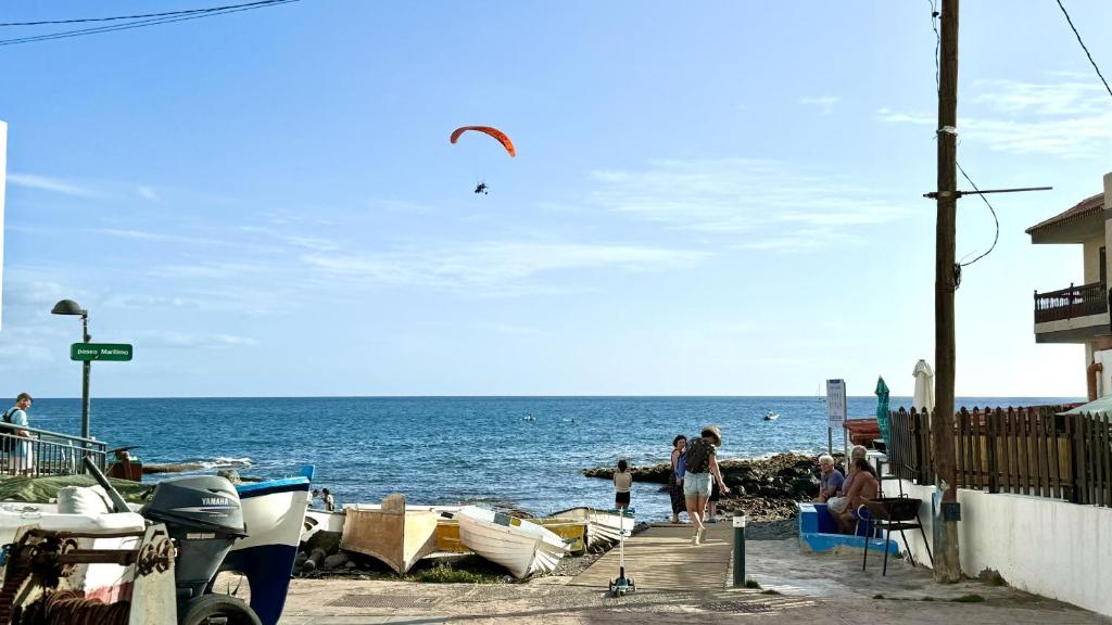 a group of people on a beach with boats at Caleta Blue Ocean on the Beach by Deihu Experiences in Adeje