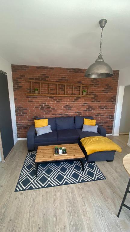- un salon avec un canapé bleu et un mur en briques dans l'établissement Ô Ciel d'Obernai, à Obernai