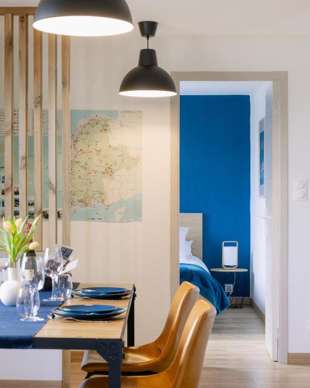 a dining room with a blue table and chairs at Maison Carn Portsall in Ploudalmézeau