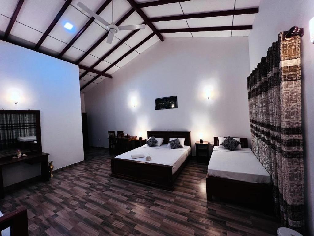 a large room with two beds and a ceiling at Sunrise oasis retreat in Habarana