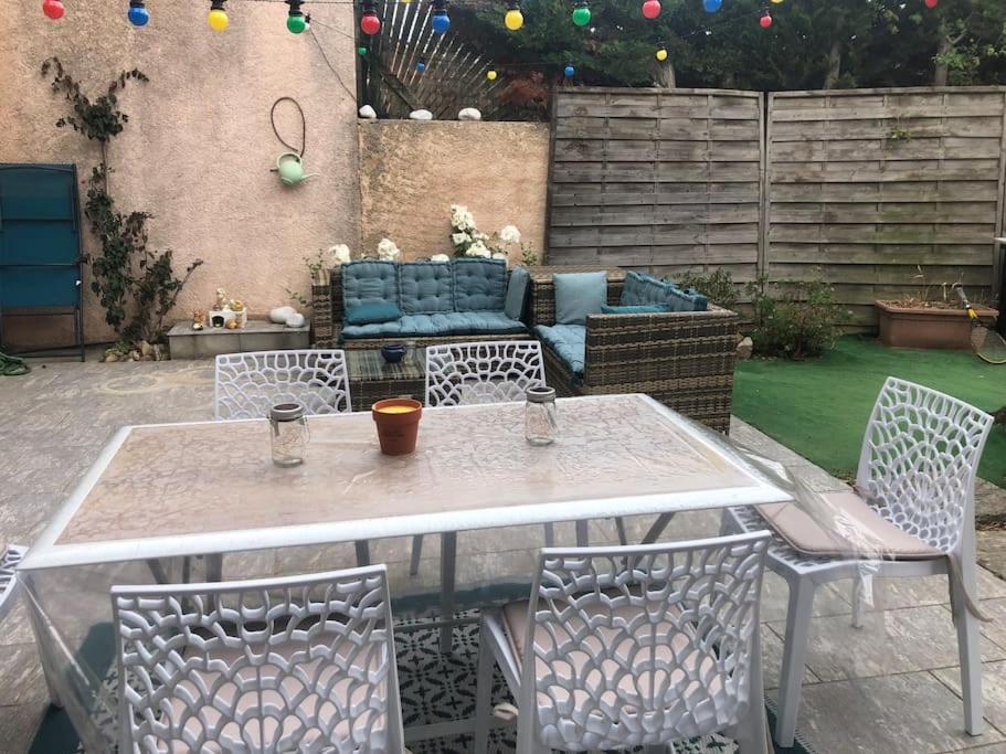 un patio avec une table, des chaises et un canapé dans l'établissement Maison avec jardin, à Sainte-Maxime