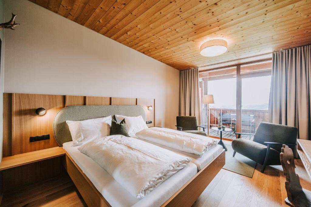 ein Hotelzimmer mit einem großen Bett und einem Fenster in der Unterkunft Hotel Marvia in Schwarzenberg im Bregenzerwald