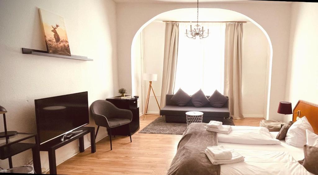 uma sala de estar com uma cama e uma cadeira num quarto em Berghotel HARZ em Hahnenklee-Bockswiese