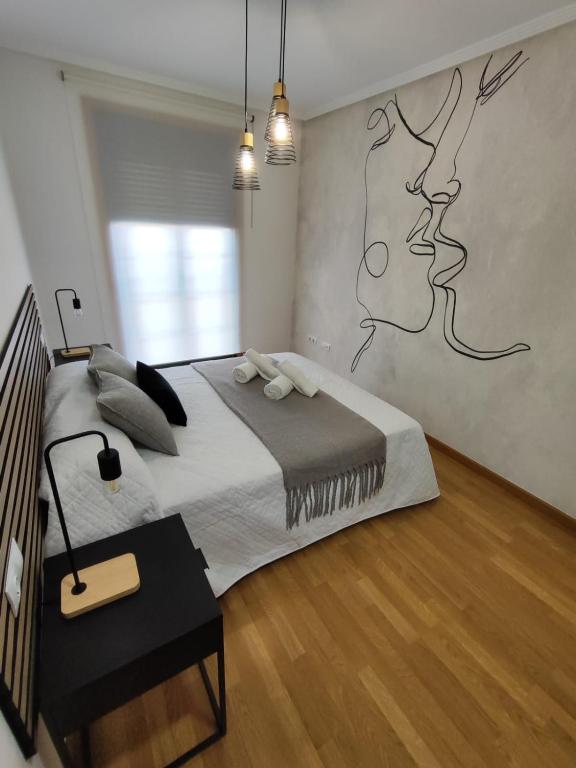 a bedroom with a bed with a drawing on the wall at Atalaia Apartment Foz in Foz
