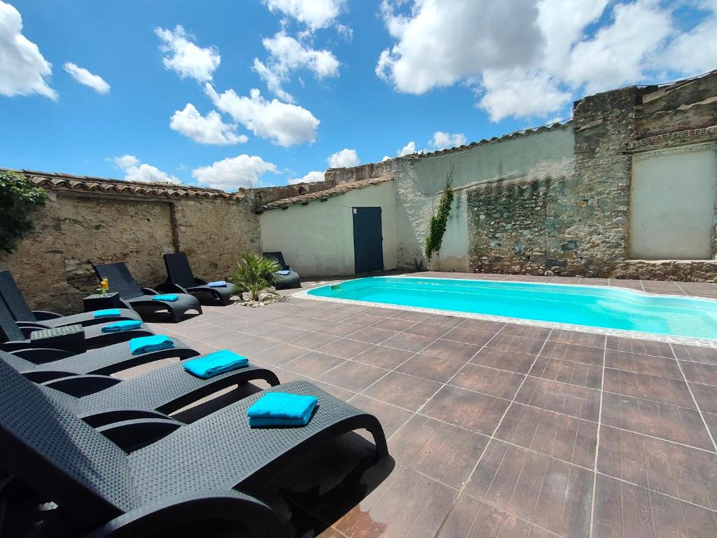 a patio with lounge chairs and a swimming pool at L'Art des Mets by Côté Jardin in Conilhac-Corbières