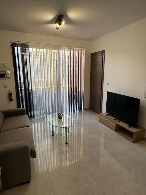 a living room with a tv and a couch and a table at Moonlight Penthouse in Gzira in Il-Gżira