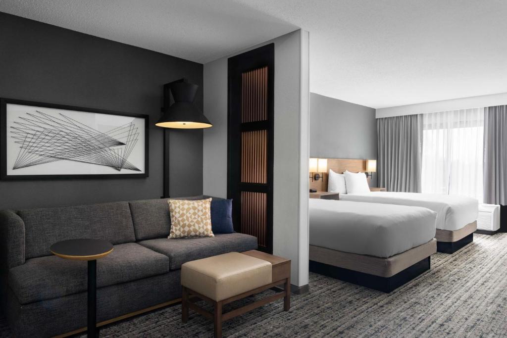 une chambre d'hôtel avec un lit et un canapé dans l'établissement Hyatt Place Colorado Springs Garden Of The Gods, à Colorado Springs