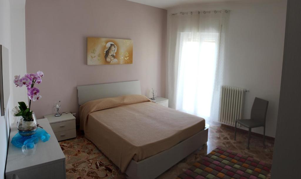 ein Schlafzimmer mit einem Bett und einer Vase aus Blumen in der Unterkunft Casa Vacanze La Perla in Matera