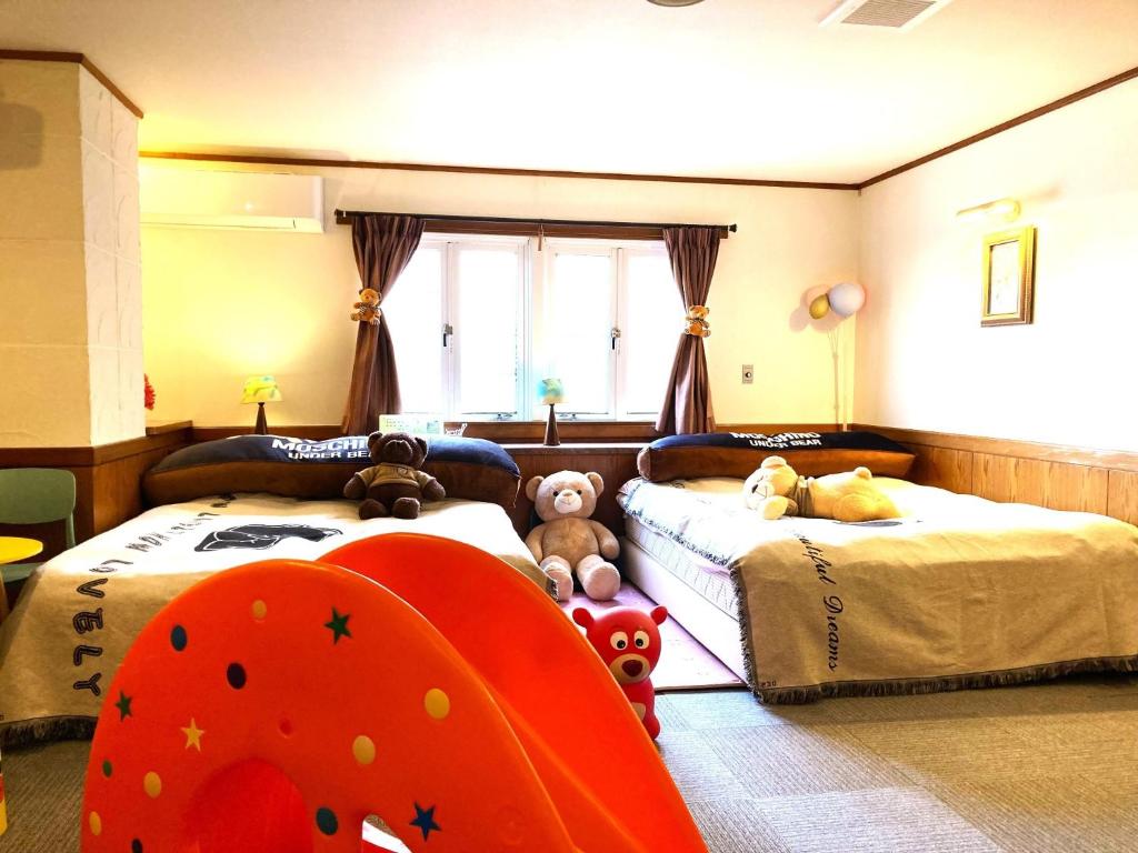 una camera con due letti con sopra animali di peluche di Ikaho Kids Paradise Hotel - Vacation STAY 56430v a Shibukawa