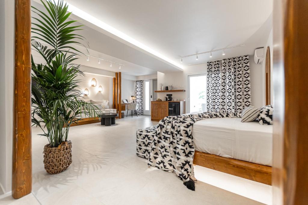 sypialnia z łóżkiem i doniczką w obiekcie Almiriki Naxos Beachside Living w mieście Plaka