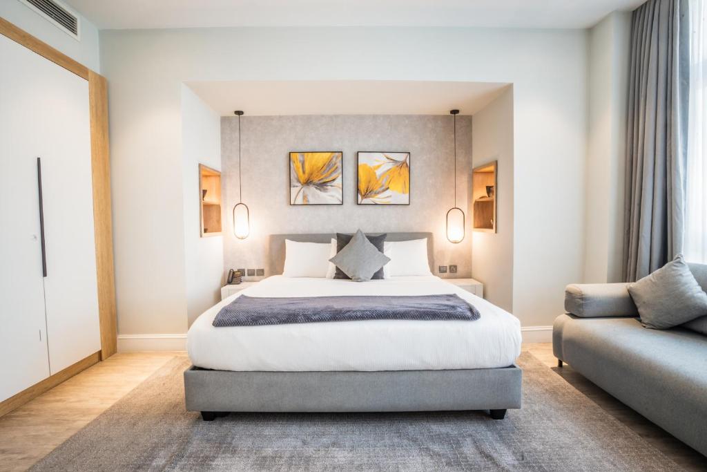 a bedroom with a large bed and a couch at Loft Hotel Apartment in Addis Ababa