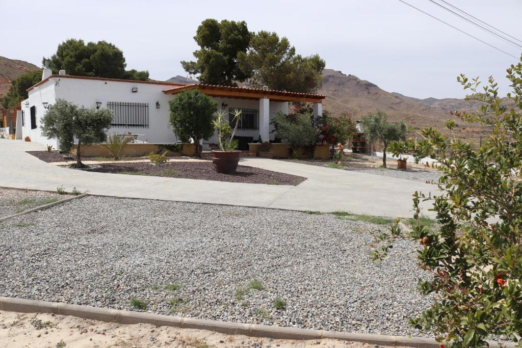 una casa con una entrada de grava delante de ella en Cortijo El Pinar 1, en Níjar
