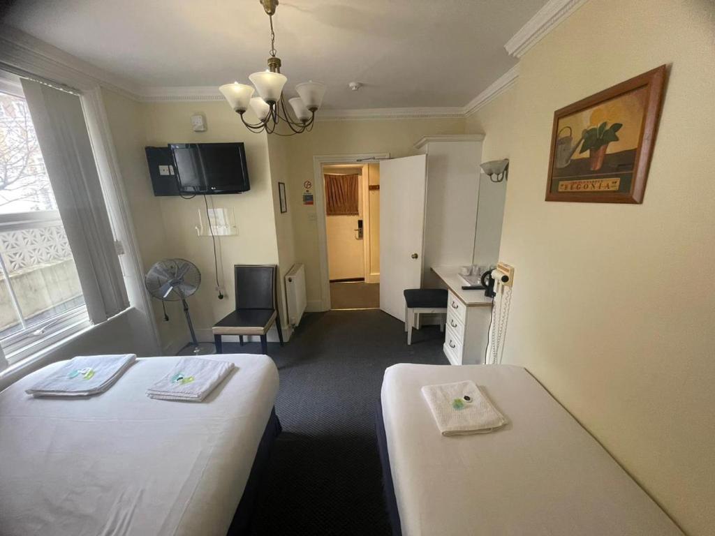 a hospital room with two beds and a desk at Manor Hotel in London