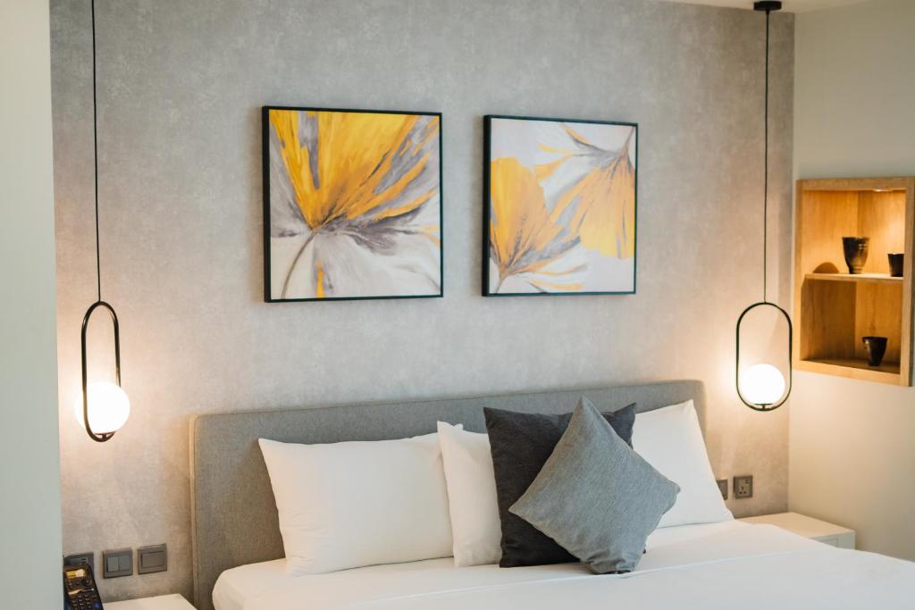 a bedroom with four pictures above a bed at Loft Hotel Apartment in Addis Ababa