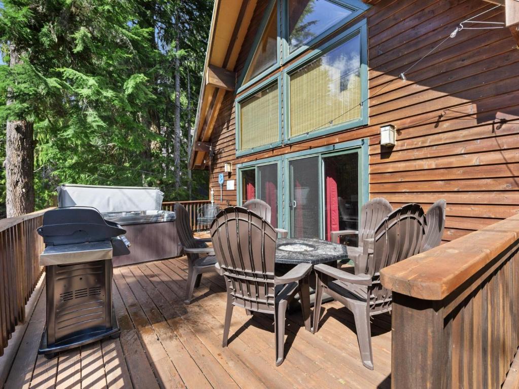 加文門特營的住宿－Govy Alpine Getaway，一个带椅子和桌子的甲板以及烧烤架