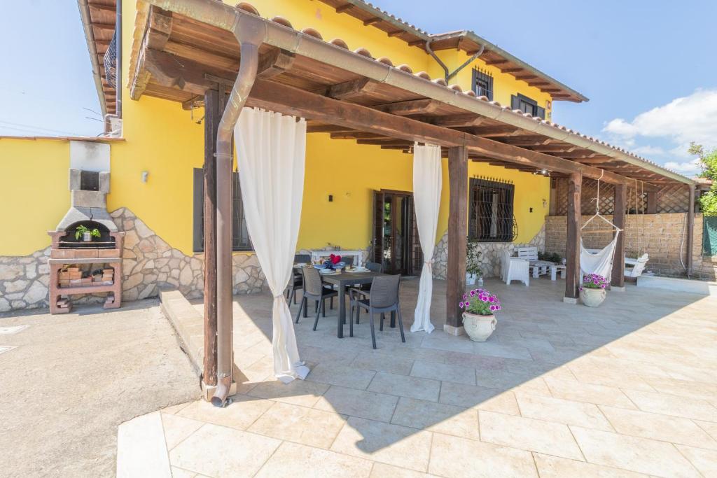 une terrasse d'une maison avec une table et des chaises dans l'établissement La casa di Lola, à Monterosi
