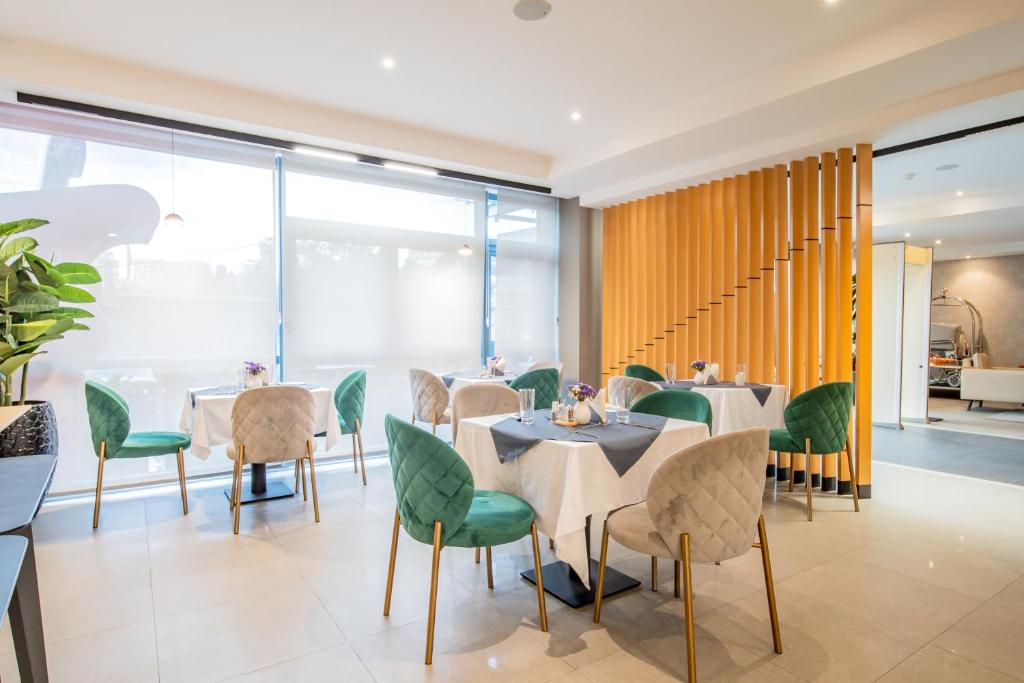 a dining room with tables and green chairs at Loft Hotel Apartment in Addis Ababa