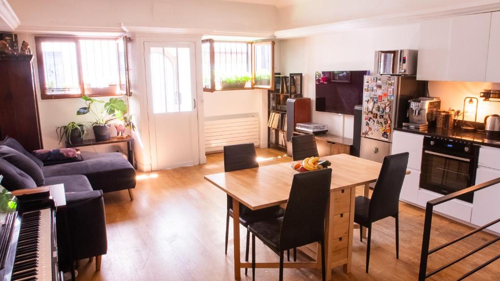 Il dispose d'une cuisine et d'un salon avec une table et un canapé. dans l'établissement Atelier artiste à Montmartre, à Paris