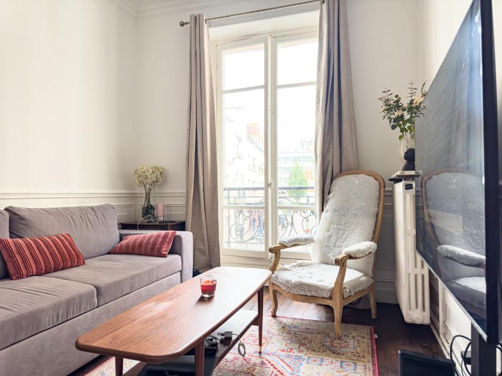 un salon avec un canapé et une table dans l'établissement PenBed-2BR- Lovely parisian apt near Bastille, à Paris