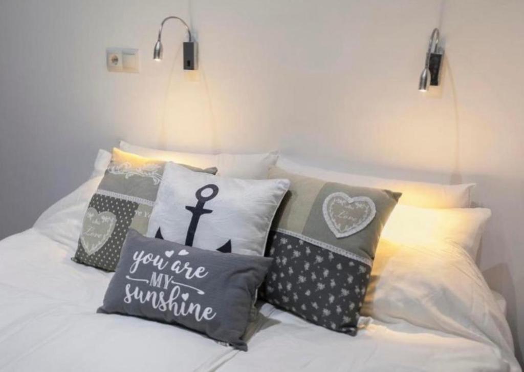a bunch of pillows sitting on a bed at Adorable urban suites in Las Palmas de Gran Canaria